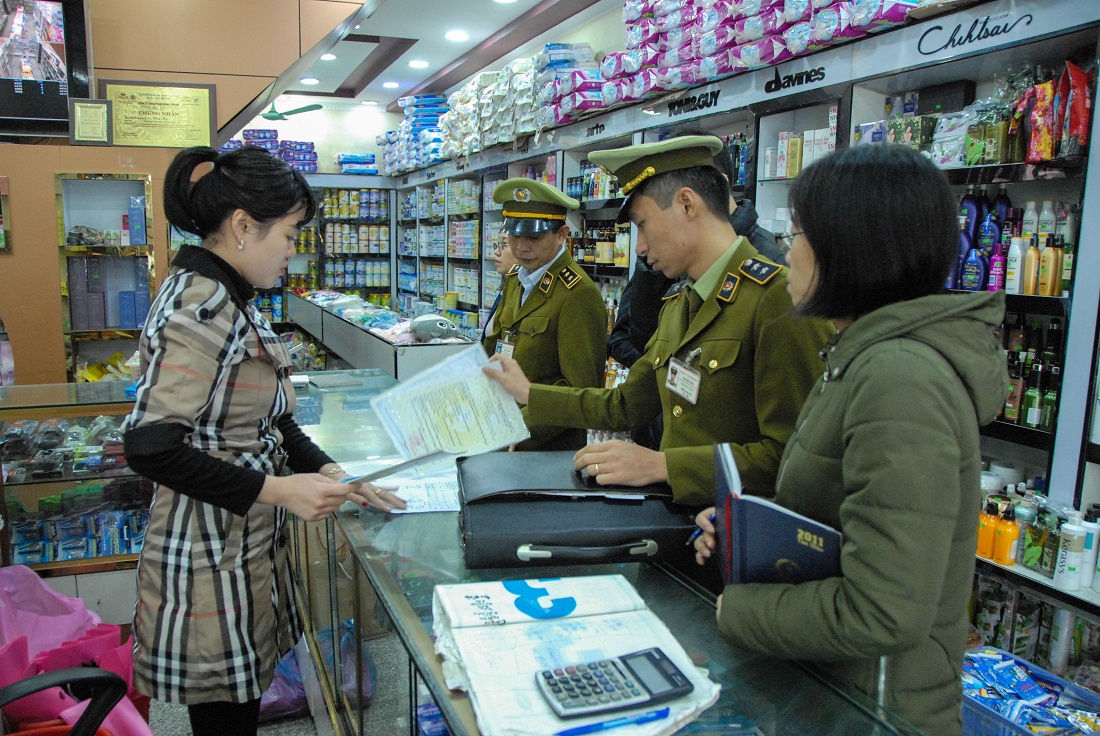 Đội Quản lý thị trường số 4 kiểm tra việc chấp hành niêm yết giá của một hộ kinh doanh tại phố Trần Phú (TP Móng Cái).