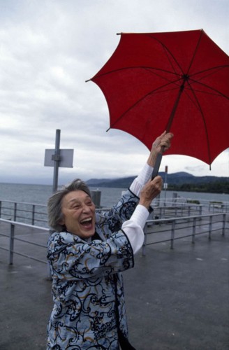 Nụ cười của một bà lão khi giữ chiếc ô bất ngờ bị gió thổi đi.