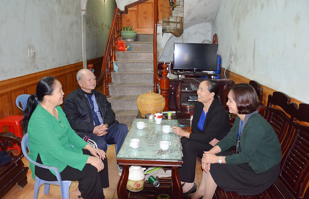 Bà Vi Thị Vinh, Phó Chủ tịch Hội Khuyến học tỉnh (bên phải) trò chuyện cùng gia đình ông Vi Văn Đa (ngồi bên trái)
