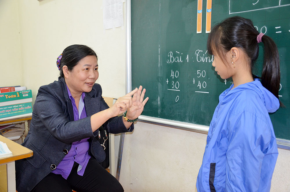 Cô giáo Hoàng Thị Yên ra ký hiệu để dạy em Trịnh Bảo Hân, lớp 1A, bị câm điếc bẩm sinh.