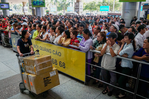 Hàng nghìn người đến đón người thân từ nước ngoài về quê ăn Tết cổ truyền vào trưa 24/1 tại sảnh đón của ga quốc tế sân bay Tân Sơn Nhất. Ảnh: Quỳnh Trần