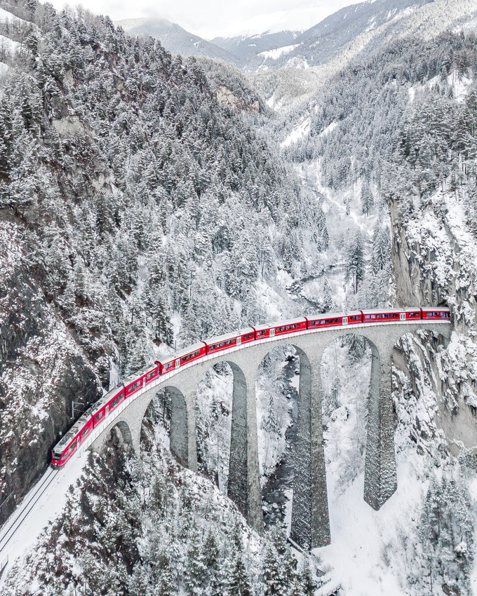 Tác phẩm “Red Train” của tác giả Sebastianmzh chụp cảnh chuyến tàu chạy lượn qua cung đường quanh núi tuyết Landwasserviadukt, Thụy Sĩ. Đây là một trong 8 bức ảnh được nhiều bạn đọc bình chọn nhất.