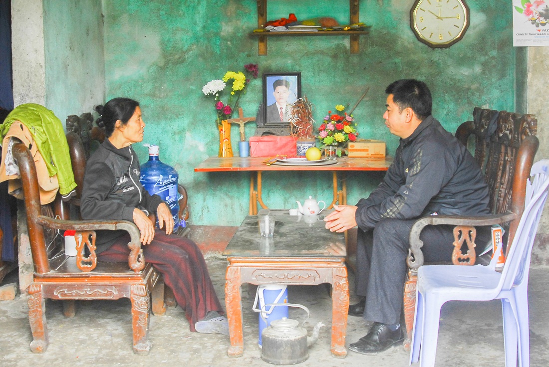 Cán bộ xã Sông Khoai (TX Quảng Yên) phổ biến chính sách hỗ trợ hộ nghèo cho bà Vũ Thị Thu là hộ nghèo của xã. 