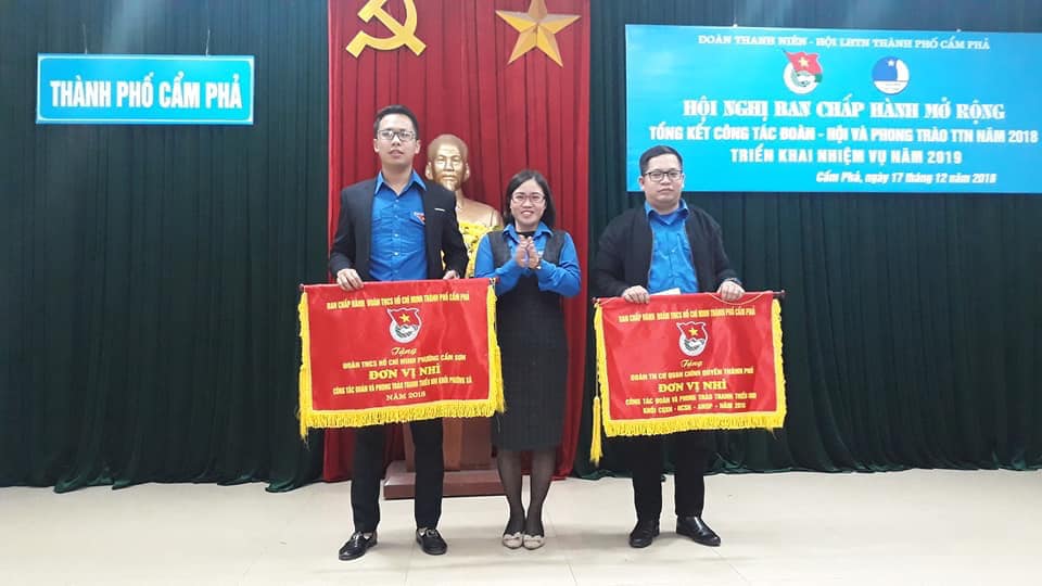 Bí thư đoàn phường Cẩm Sơn Đỗ Trần Hanh (trái) nhận cờ thi đua về công tác đoàn - phong trào thanh thiếu nhi của TP Cẩm Phả