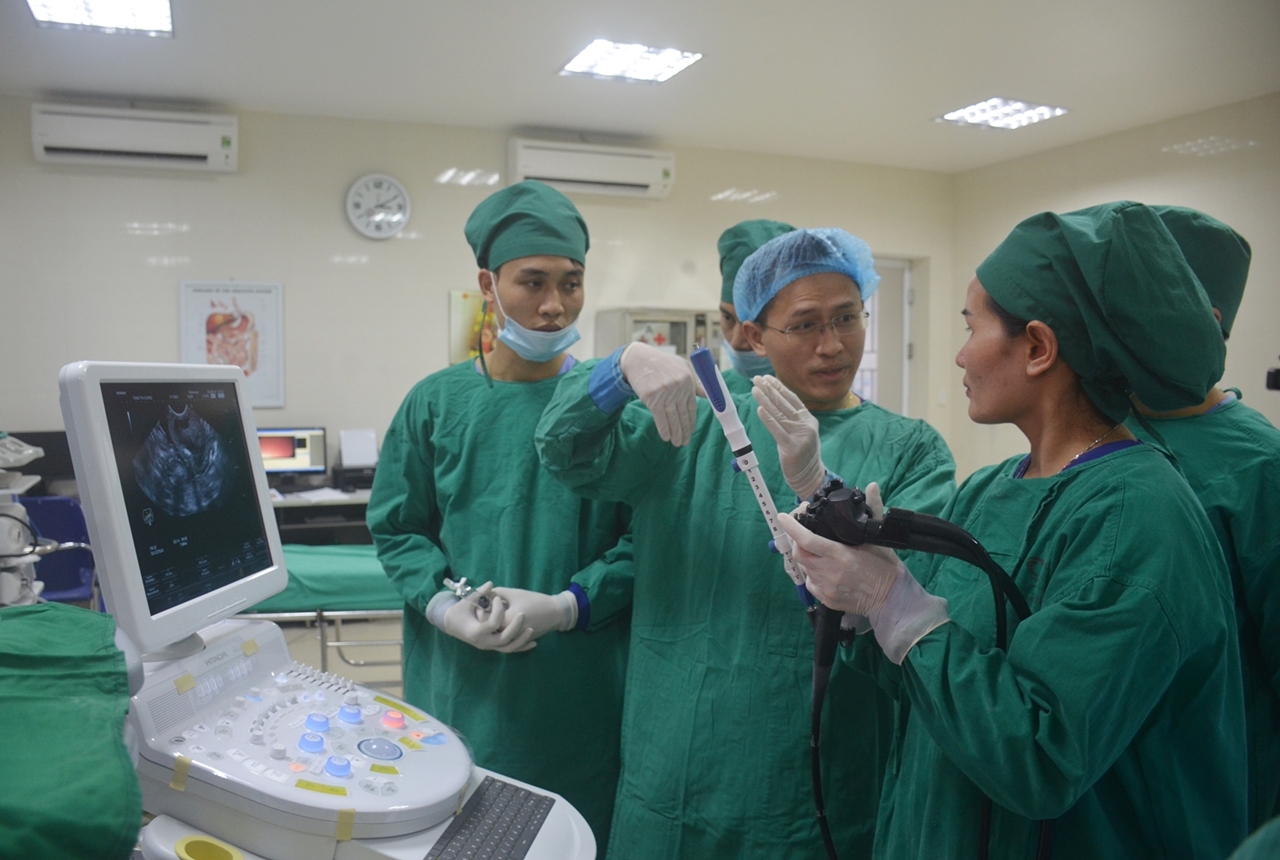 Giáo sư Nguyễn Quốc Nam (ngoài cùng, bên trái) hướng dẫn các bác sỹ của Bệnh viện Bãi Cháy kỹ thuật siêu âm nội soi tiêu hóa.