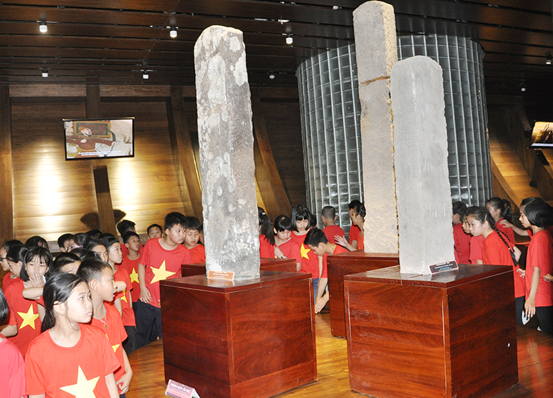 Các em học sinh tham quan cột mốc cổ trưng bày tại Bảo tàng Quảng Ninh.