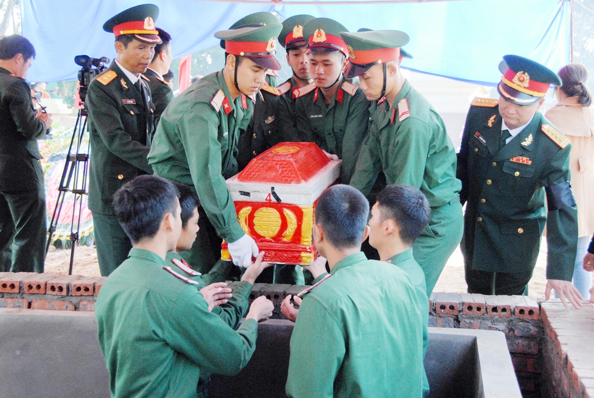 Hài cốt của các anh được những người đồng đội thời bình kính cẩn đưa vào trong rợp bóng Quốc kỳ 