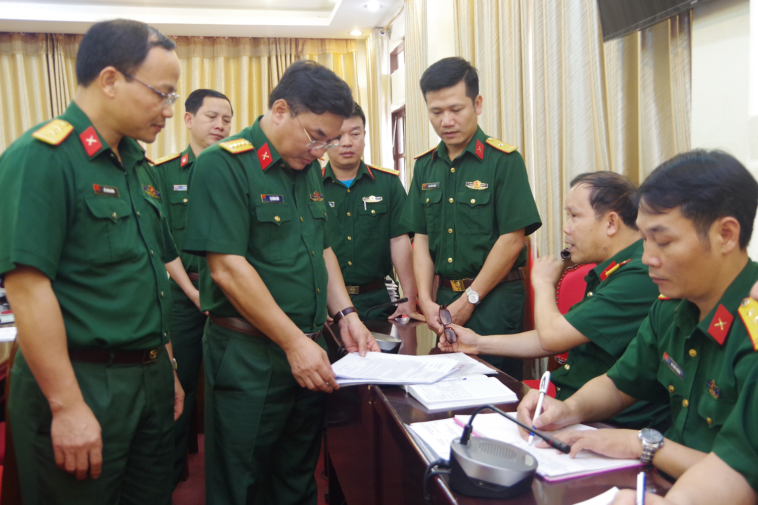 Đại tá Tạ Xuân Thủy, Phó Cục trưởng Cục 71/ Tổng cục II (đứng thứ 2 bên trái ảnh) kiểm tra sổ sách của Ban quân báo, trinh sát Bộ CHQS tỉnh.