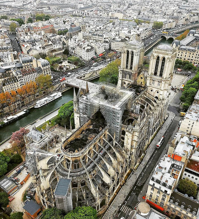 Nhà thờ Đức Ba Paris nhìn từ trên cao sau vụ cháy khủng khiếp kéo dài hơn 8h. Phần mái của Nhà thờ đã bị đổ sập để lại những mảng đen lớn (Ảnh: Daily Mail)