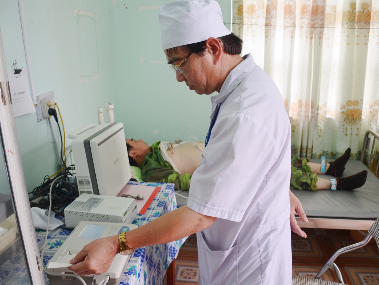 Bác sĩ thực hiện điện tim cho người bệnh tại trạm y tế xã Yên Đức