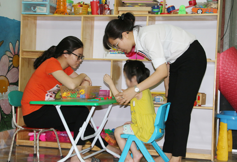 Chị Bùi Kiều Chinh (bên trái) hướng dẫn cho học sinh trung tâm trong giờ can thiệp cá nhân.