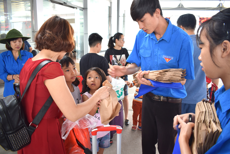 Các ĐVTN theo sự chỉ đạo của Thái đi vận động và phát túi thân thiện môi trường cho du khách trước khi đến Cô Tô