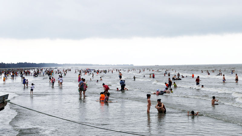 Mặc dù thời tiết không thuận lợi, nhưng Bãi biển Trà Cổ thu hút đông du khách đến tắm biển.