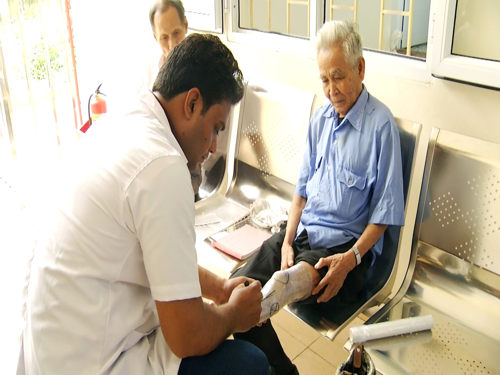 Kỹ thuật viên của tổ chức BMVSS lắp chân giả cho người khuyết tật tại Quảng Ninh.