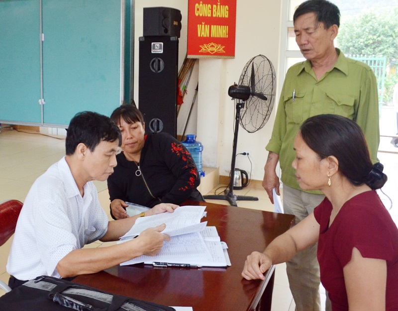 CCB Nguyễn Văn Bội hướng dẫn người dân Khu 8, phường Hà Phong làm thủ tục hành chính liên quan người dân.