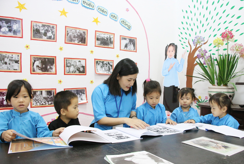 Cô và trò Trường Mầm non Húc Động (xã Húc Động, huyện Bình Liêu) đọc sách về Bác Hồ tại thư viện Nhà trường 