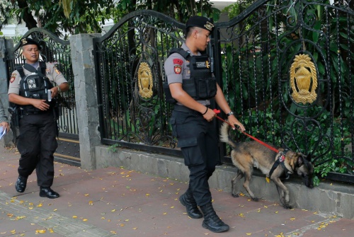 Cảnh sát Indonesia và chó nghiệp vụ tuần tra tại Jakarta hồi tháng 4. Ảnh: AP.