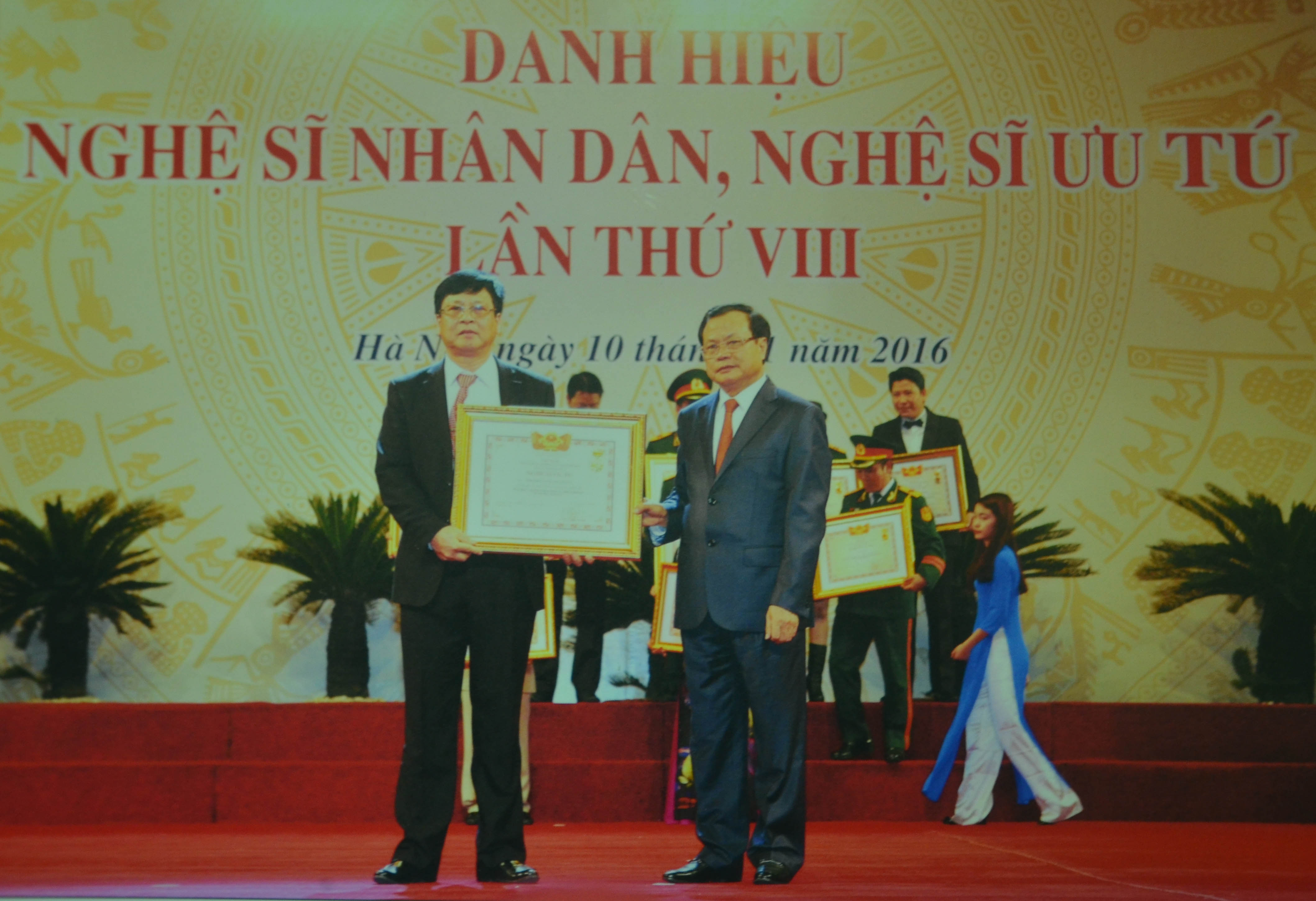 Ông Phạm Hữu Lượng (trái) đón nhận danh hiệu Nghệ sĩ Ưu tú. (Ảnh: Nhân vật cung cấp). 
