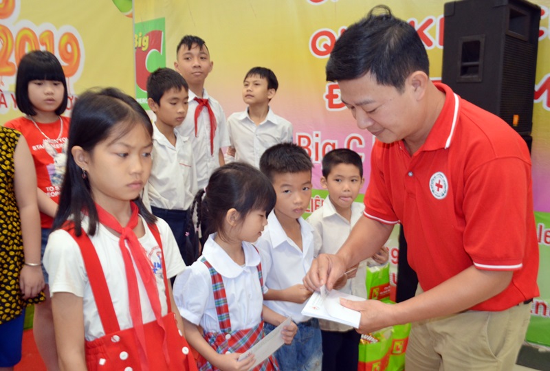 Ông Phạm Văn Thơ, Chủ tịch Hội CTĐ TP Hạ Long trao quà cho các em hoàn cảnh khó khăn.