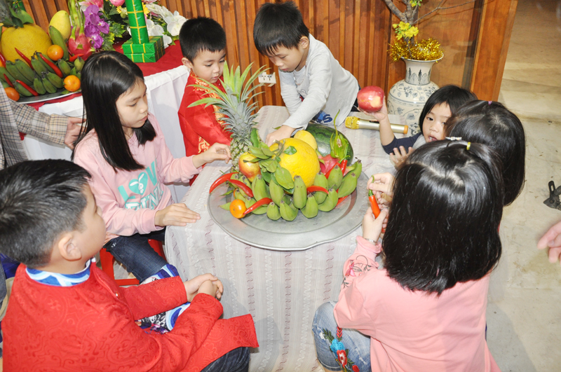Các em nhỏ thử sức khi tham gia bày mâm ngũ quả và trang trí cành mai Tết trong chương trình trải nghiệm Tết năm 2019 tại Bảo tàng Quảng Ninh.