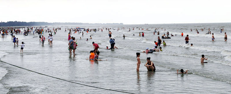 Khách du lịch tắm trên bãi biển Trà Cổ, bãi biển dài nhất Việt Nam.