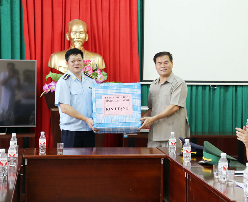 Đồng chí Bùi Văn Khắng tặng quà của UBND tỉnh cho Chi cục Hải quan Cửa khẩu Bắc Phong Sinh.