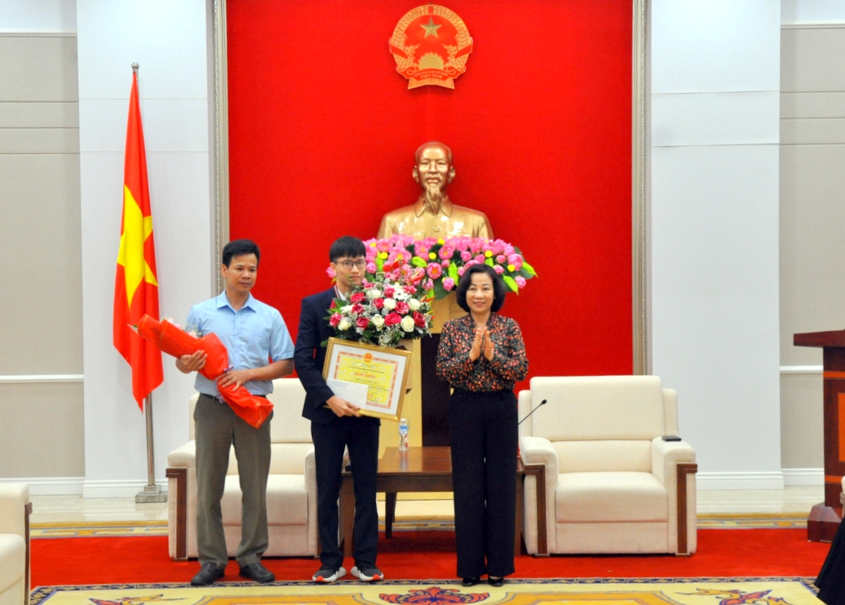 Phó Chủ tịch UBND tỉnh Vũ Thị Thu Thủy trao bằng khen của UBND tỉnh cho học sinh Trần Ngọc Khánh và khen thưởng thầy giáo Nguyễn Ngọc Phúc.