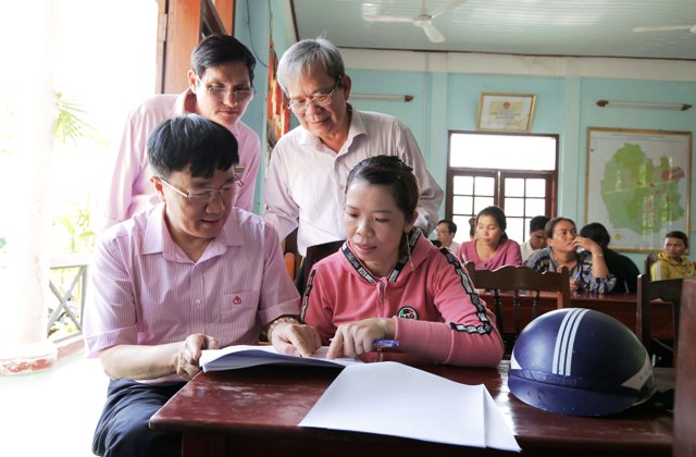 Lãnh đạo Ngân hàng Chính sách xã hội trao đổi tình hình sử dụng vốn vay của tổ viên với Tổ trưởng Tổ tiết kiệm và vay vốn tại Ðiểm giao dịch xã Canh Thuận.