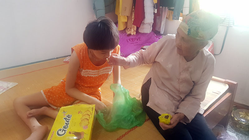 Bà Hoàng Thị Tính, hơn 80 tuổi thôn Hà Lai, xã Tân Lập, ngày ngày vẫn phải chăm sóc đứa cháu khuyết tật đặc biệt nặng.