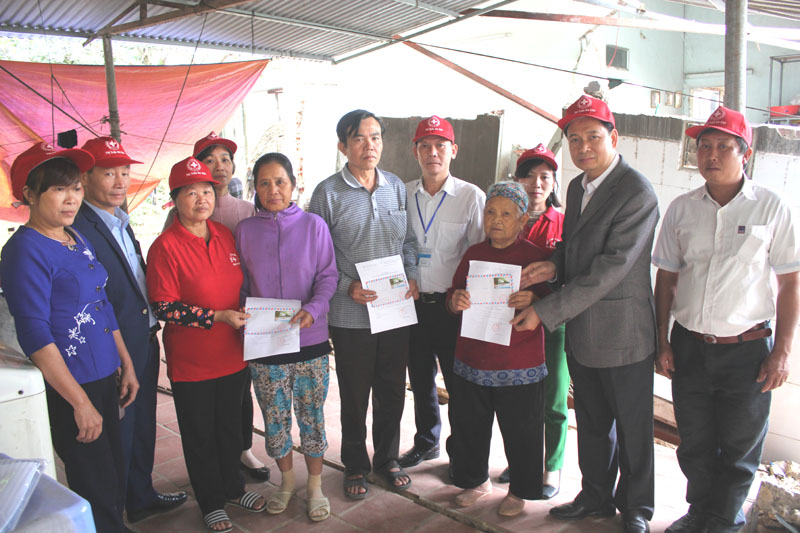 Bà Ngô Thị Thuận (thứ 3 từ bên phải) trong buổi trao quà hỗ trợ cho các hộ bị ảnh hưởng bão lũ ở thị trấn Ba Chẽ