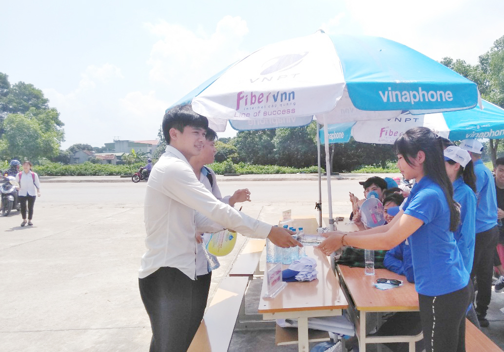 Lực lượng thanh niên tình nguyện phát nước miễn phí cho thí sinh tại điểm thi THPT Quảng Hà (huyện Hải Hà)
