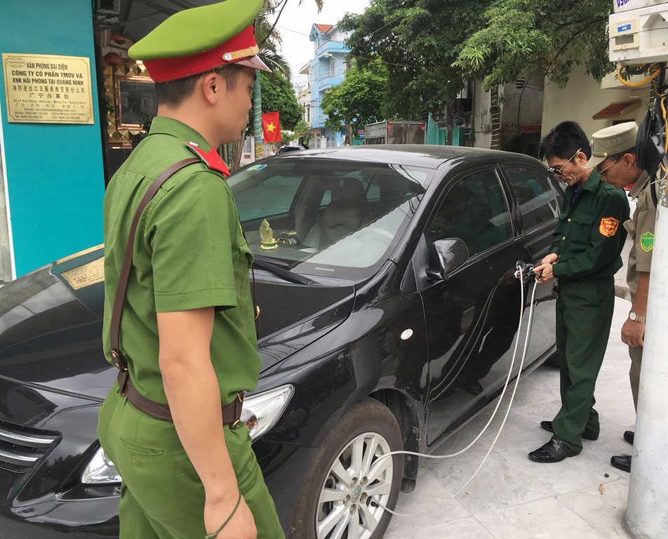 Lực lượng chức năng xử lý xe ô tô đỗ trên hè phố trái quy định đợt ra quân giữa tháng 6/2019.