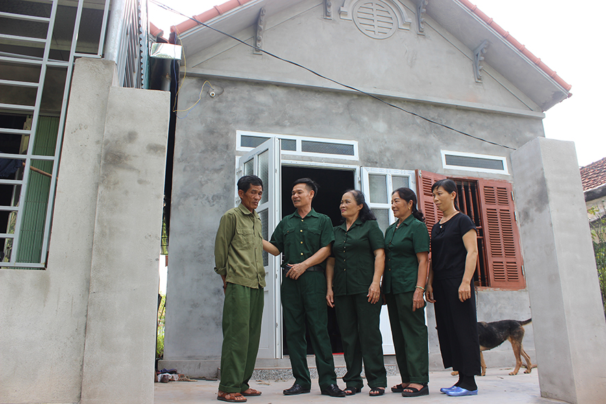 Hội viên Cựu TNXP Nguyễn Văn Hệ,( bên trái) Móng Cái trước ngôi nhà mới hoàn thành nhờ công lao rất lớn sự sẻ chia vì nghĩa tình đồng đội cựu TNXP phường và thành phố.
