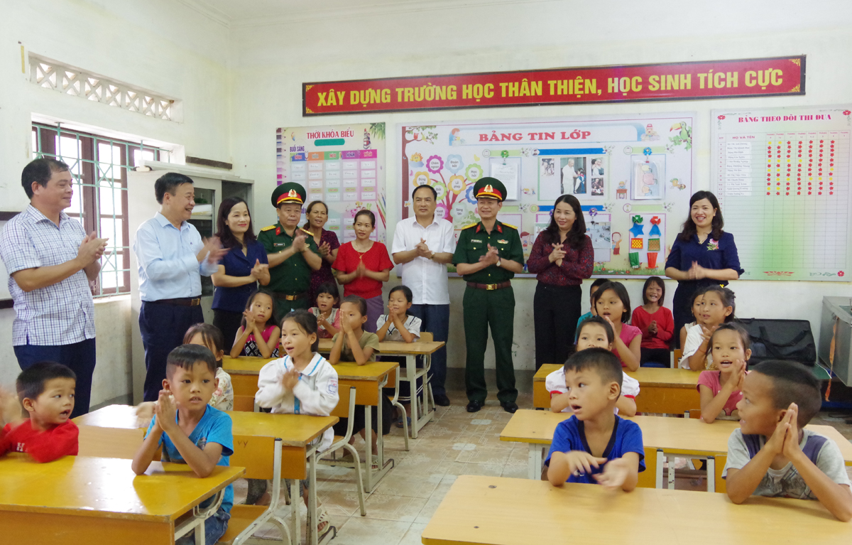 Các đại biểu thăm hỏi, động viên các em học sinh điểm trường thôn Làng Han, xã Đồn Đạc, huyện Ba Chẽ.