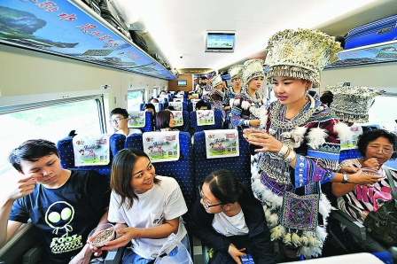 Nhân viên ngành đường sắt  trong trang phục dân tộc chào đón những vị khách đầu tiên của tuyến đường sắt cao tốc Nam Ninh - Hồng K ông. 