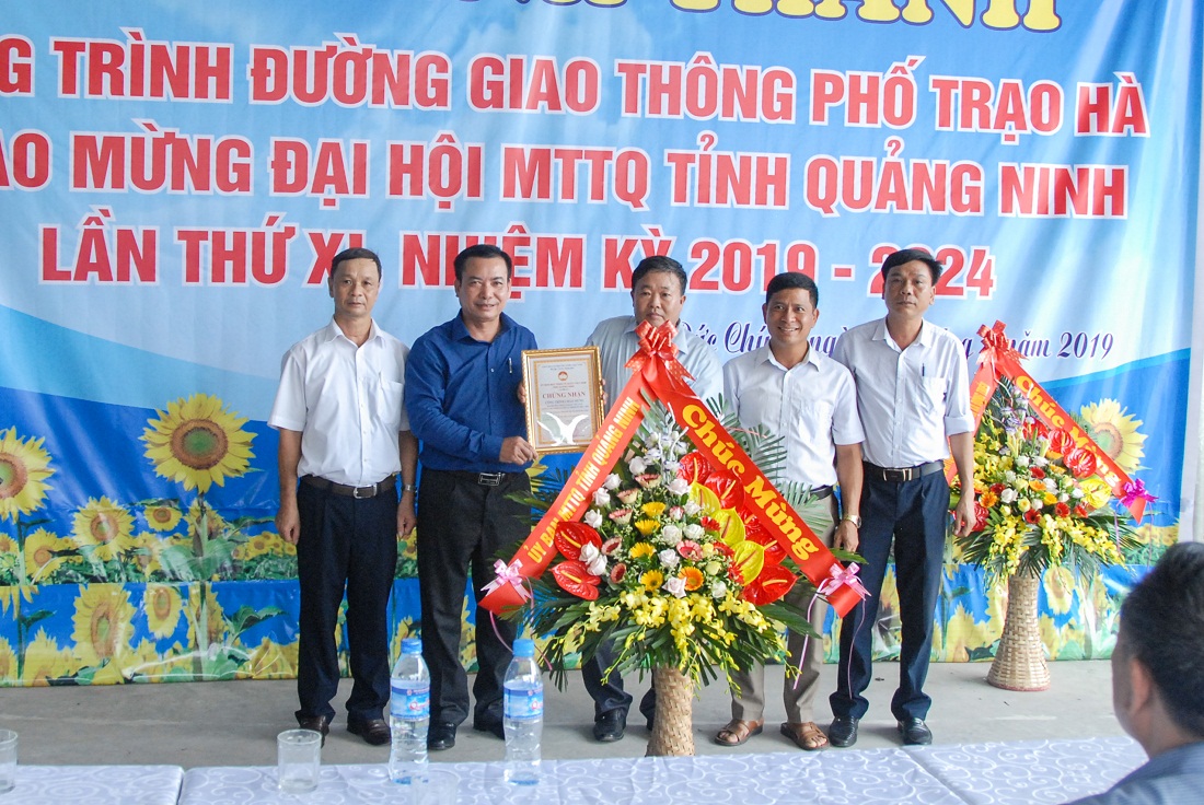 Lãnh đạo Ủy ban MTTQ tỉnh (ngoài, bên trái) trao chứng nhận công trình chào mừng Đại hội MTTQ tỉnh cho lãnh đạo, nhân dân khu phố Trạo Hà và phường Đức Chính (TX Đông Triều).