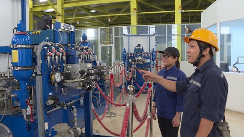 Chị Nguyễn Thị Hường- Công nhân Phân xưởng vận tải Giếng đứng đang được hướng dẫn vận hành thiết bị trục tải giếng đứng dẫn về cách