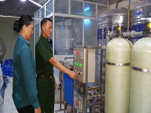 CCB Trần Đức Nghiêm hướng dẫn công nhân sử dụng máy sản xuất nước lọc đóng chai.