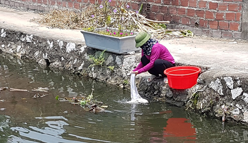 Người dân xã đảo Hà Nam vẫn sử dụng nguồn nước không đảm bảo vệ sinh từ kênh, mương để giặt giũ. 
