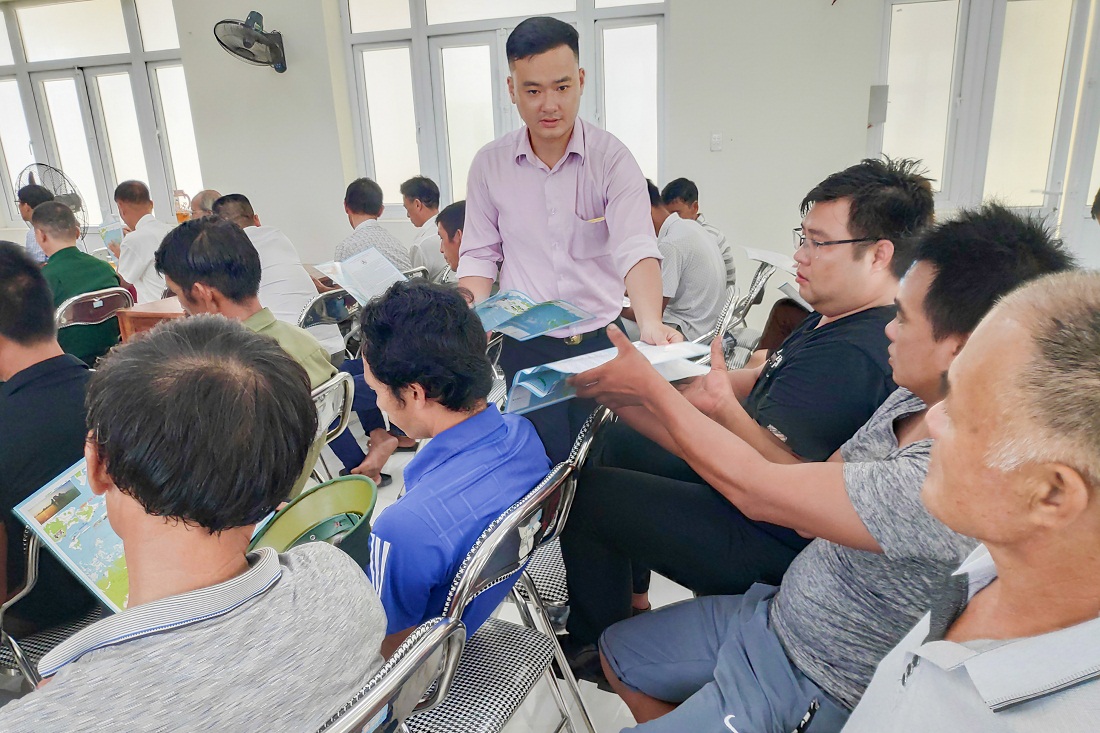 Người dân xã Cẩm Hải (TP Cẩm Phả) nhận tờ gấp pháp luật về quy định vùng cấm, ngư cụ cấm trong khai thác thủy sản.
