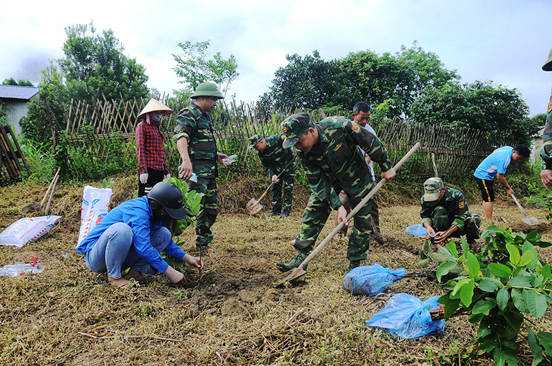 Cán bộ, chiến sỹ Đồn BP Pò Hèn giúp người dân thôn xây dựng vường mẫu. (Ảnh do đơn vị cung cấp) 