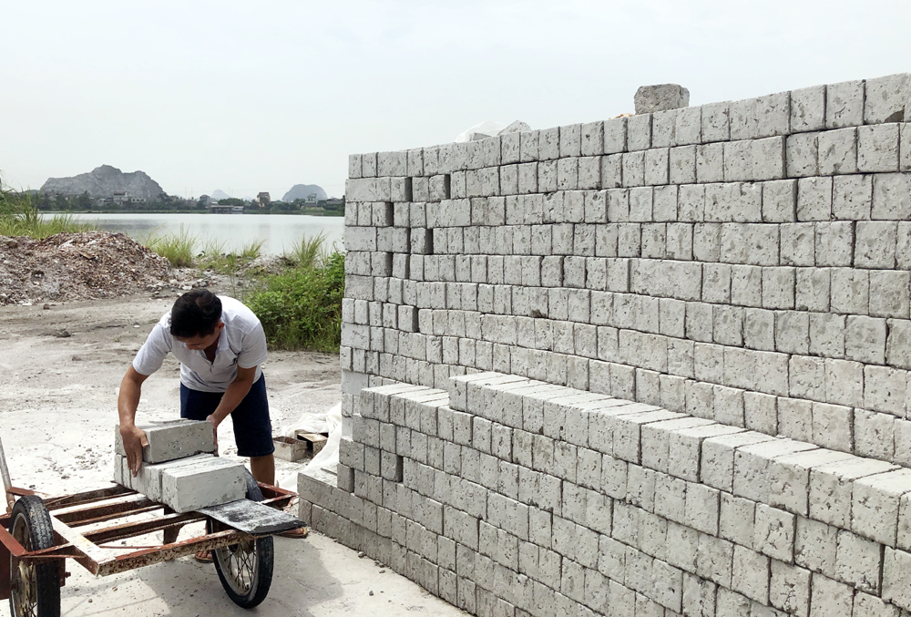 Trong khi chờ thủ tục chuyển sang phát triển kinh tế gia trại anh Nguyễn Canh Thân tận dụng trạt xỉ đóng gạch bán duy trì cuộc sống