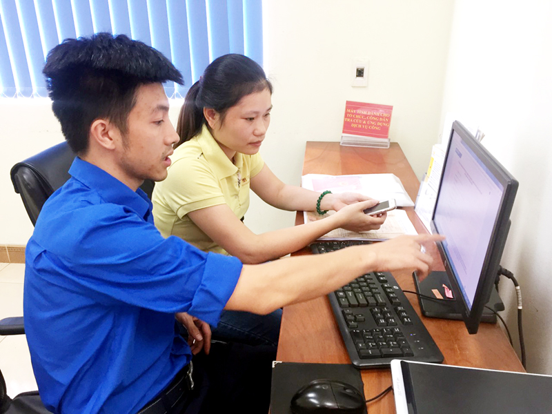 ĐVTN hướng dẫn chị Bùi Thúy Phương (phường Cẩm Bình, TP Cẩm Phả) sử dụng dịch vụ công trực tuyến tại Trung tâm Hành chính công TP Cẩm Phả.