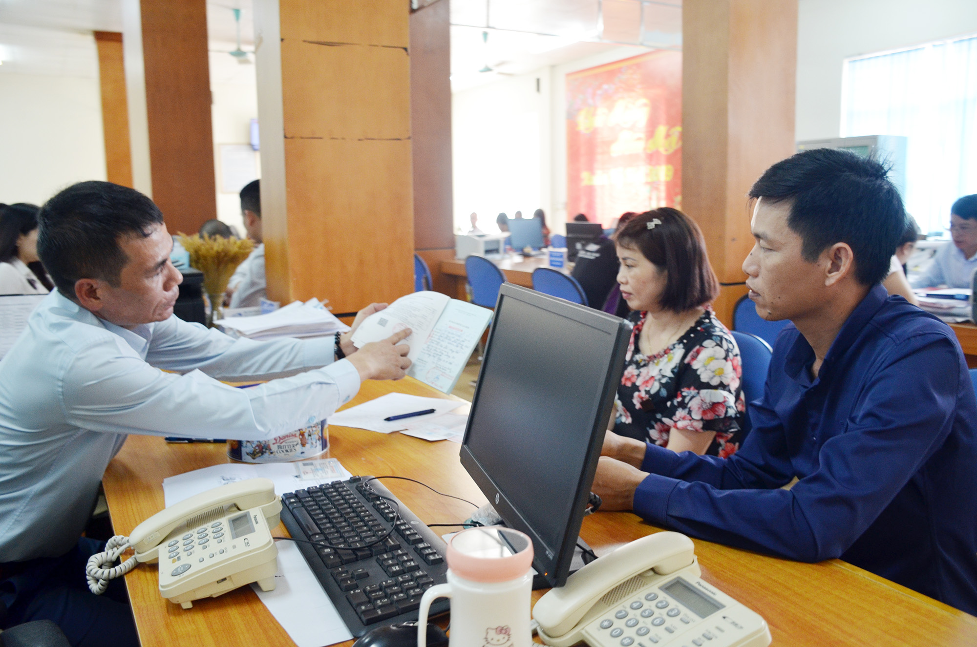 Cán bộ Trung tâm Hành chính công Vân Đồn trao đổi với người dân đến làm thủ tục hành chính.
