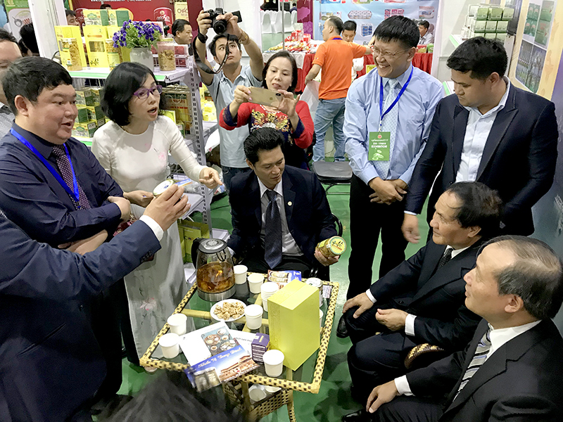 Các thành viên trong đoàn công tác Quảng Ninh giới thiệu sản phẩm OCOP cho đại biểu tham quan gian hàng tại Hội chợ thương mại Việt-Lào 2019 (VietLao EXPO).