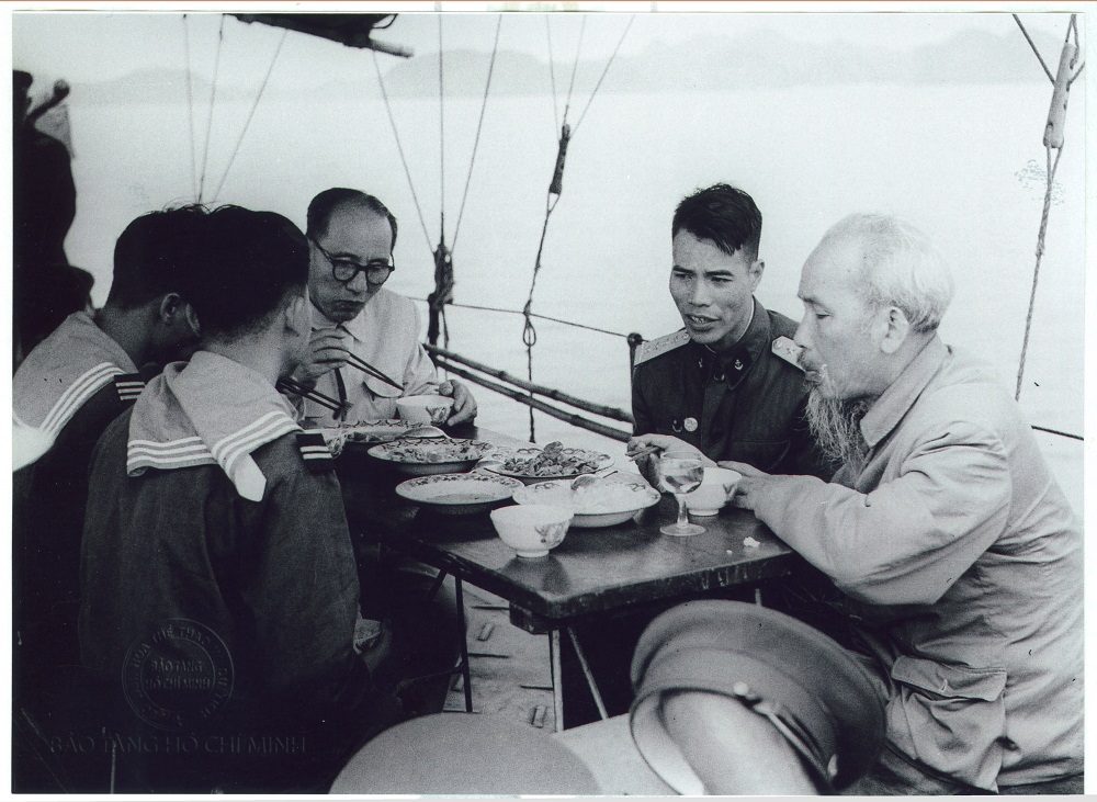 Chủ tịch Hồ Chí Minh và đồng chí Nguyễn Lương Bằng, Trưởng ban Ban Kiểm tra Trung ương Đảng chụp ảnh lưu niệm và ăn cơm cùng cán bộ, chiến sĩ tàu hải quân T.524 tại cảng Bãi Cháy, ngày 30/3/1959. 