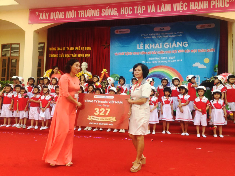 Bà Đỗ Thị Hào - Đại diện Head Nam Dương trao mũ cho học sinh lớp Một Trường tiểu học Trần Hưng Đạo, TP Hạ Long