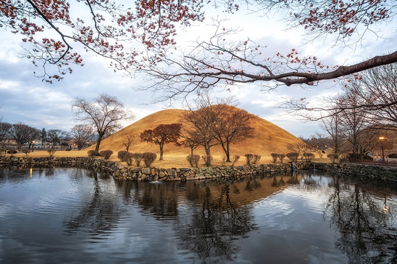  Khu lăng mộ Daereungwon  Daereungwon là quần thể gồm nhiều lăng mộ của các vị vua và hoàng hậu. Nhưng nổi tiếng nhất trong khu di tích lịch sử này là công viên lăng mộ Tumuli - nơi tọa lạc của 23 trong số 200 lăng mộ được tìm thấy ở cố đô Gyeongju. Những lăng mộ như đồi núi thu nhỏ được phủ cỏ xanh tươi vào mùa xuân và ngả vàng khi sang thu. Ảnh: Aaron choi.