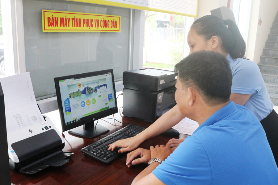 Cán bộ Trung tâm HCC Thị xã Đông Triều hướng dẫn người dân tra cứu dịch vụ công trực tuyến mức độ 3,4.