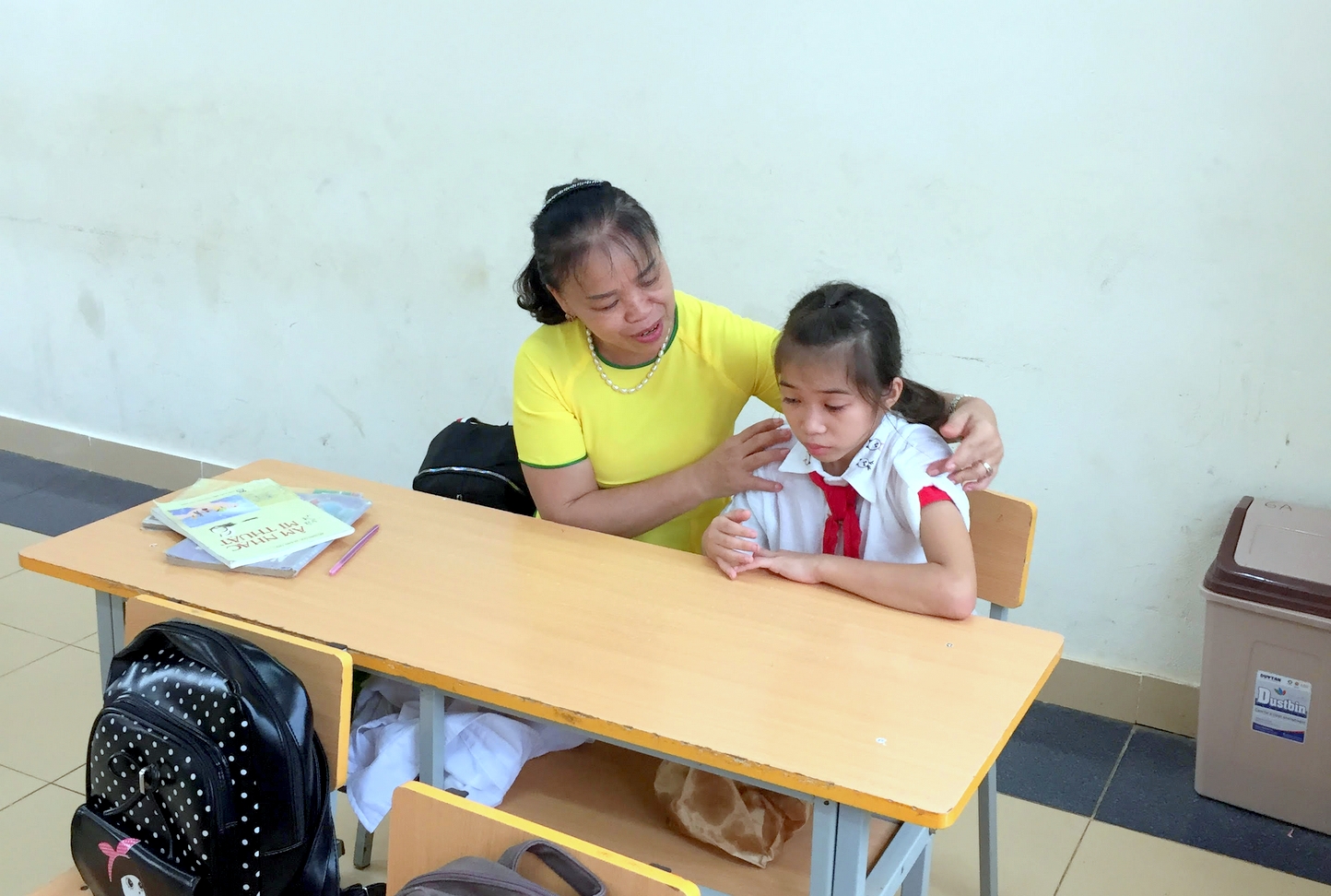 Cô Vịnh ân cần dỗ dành, động viên một học sinh lớp 6, lần đầu tiên xa nhà đi học bán trú trong ngày khai giảng năm học mới 2019-2020. (Ảnh do thầy cô Trường PDDT Bán trú THCS Nam Sơn cung cấp).
